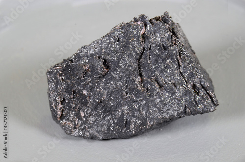 Piece of Neodymium (Nd). The piece is covered with a thin layer of oil to prevent air contact