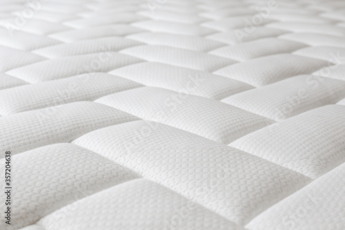 Close up shot of white orthopedic mattress top side surface pattern with a lot of copy space for text. Hypoallergenic foam matress for proper spinal alingment and pressure point relief. Background.