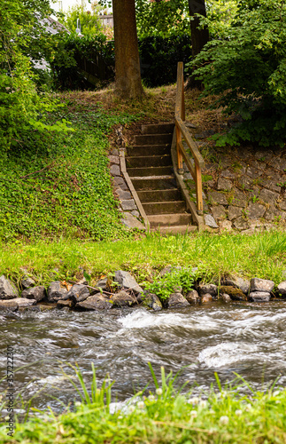 Kamienne schody nad rzeka. Zejscie do wody. Drewniane balustrady. Kamienn brzeg. Tereny rekreacyjne w miescie.
