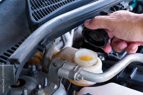 Check brake fluid,Hand open a tank for car maintenance.