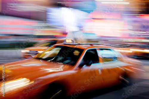 Blurred view of taxi on city street at night