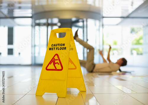 Businessman slipping on wet office floor