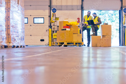 Workers checking boxes in warehouse