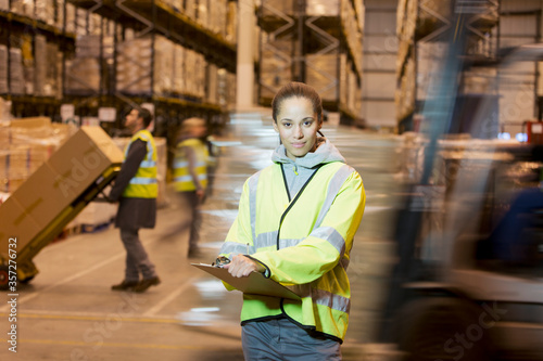 Worker holding clipboard in warehouse