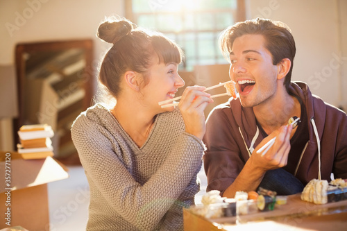 Couple eating sushi together in new home