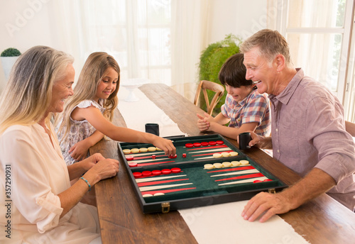 Grandparents and grandchildren playing backgammon