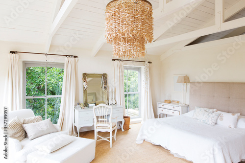 Chandelier and armchair in rustic bedroom