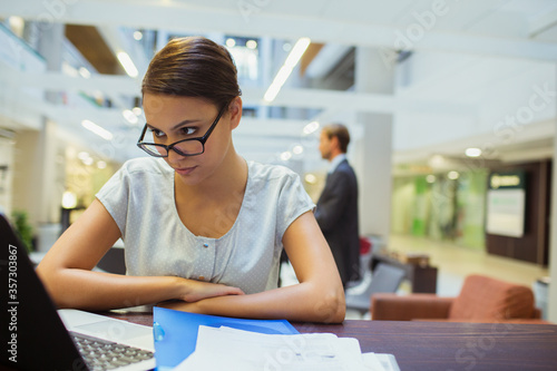 Businesswoman working on laptop in office building