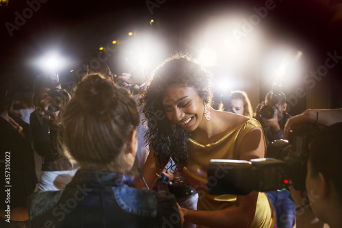 Celebrity signing autographs for fans at event