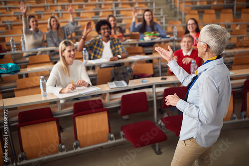 Female elderly professor answering student's questions