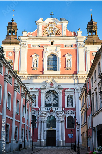 facade of the baroque church decorated with columns and statues in Poznan.