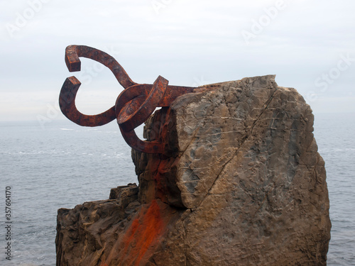 Horizontal view of the sculpture "Peine del Viento", with the Cantabrian Sea in the background on a winter day, San Sebastián, España