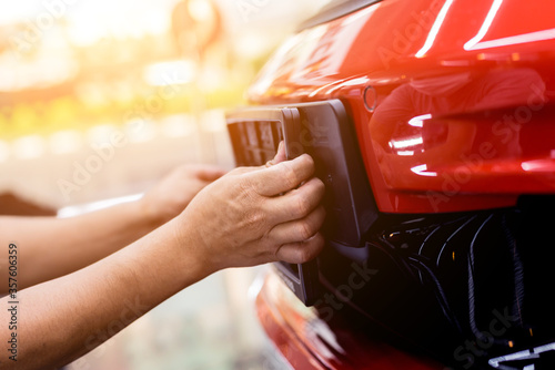 Technician changing car plate number in service center.