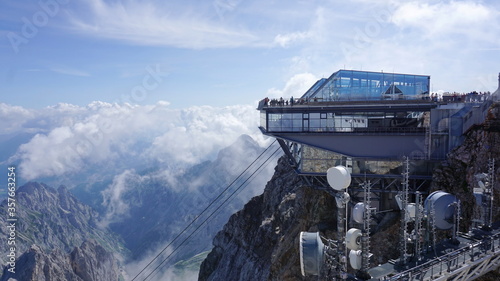 Viewing platform in the Alps with glass architecture. In the front you can see the radio station with antenna mast and satellite system. Zugspitze, mountain in Germany, highest peak.