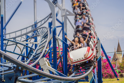 Happy friends in amusement park on a summer day