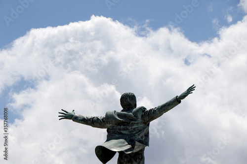 Bronze statue dedicated to the Italian singer Domenico Modugno on the promenade of Polignano a Mare, Puglia, Italy