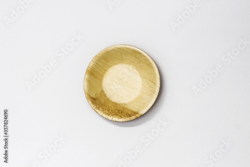 Round Areca Leaf Bowl, eco-friendly disposable cutlery. Top view on a white background.