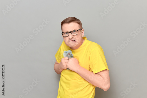 Portrait of funny greedy man holding money in hands