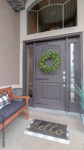 Vertical crop Gray front door entrance with wreath and sidelights under large transom window
