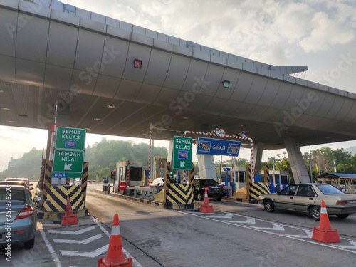 SEREMBAN, MALAYSIA -MAY 26, 2020: Highway toll canopy in Malaysia. Vehicles that use the expressway through a toll plaza and make payments each time they enter and exit.