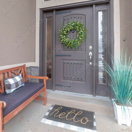 Square Gray front door entrance with wreath and sidelights under large transom window