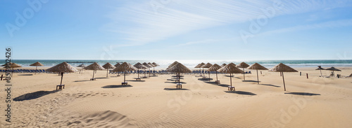 Beach umbrellas on the the beautiful unique sand beach. Vacation and summer holidays concept. Banner and panoramic edition.