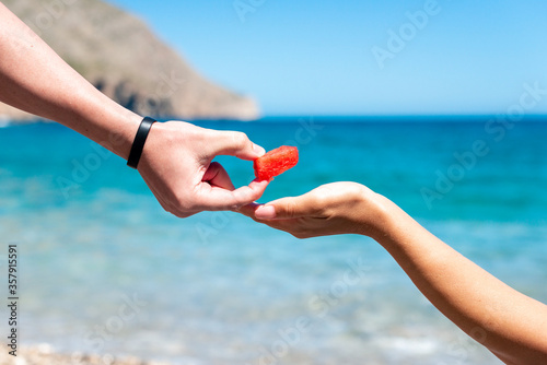 two people on beach picnic sharing healthy fruit in summer in heavenly place, summer concept