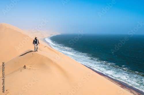 Tourist admiring the view from a sand dune at Sandwich Harbour