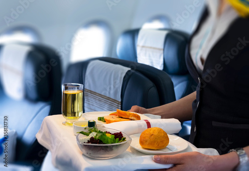 flight attendant serving meal in an airplane