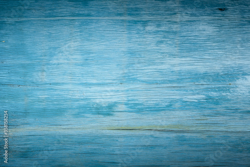 background of old wooden cracked plywood painted with blue paint