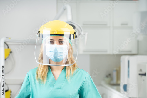 Mujer dentista con mascarilla y equipo de protección individual, EPI, garantizando la máxima seguridad para los pacientes en contra del coronavirus COVID-19