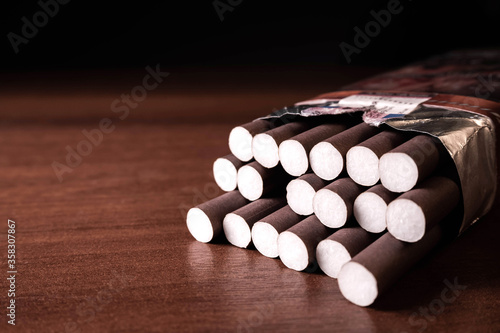 Brown cigarillos on a wood black background