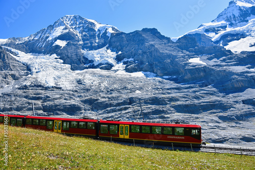 Beautiful scenery with cogwheel red train of the famous Jungfrau Railway from Jungfraujoch ( Top of Europe) to Kleine Scheidegg, Bernese Oberland, Switzerland 