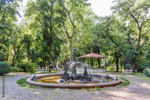 Vrsac, Serbia - June 04, 2020: Part of the fountain in the city park in Vrsac. Hiking trail through the alley in the city park.