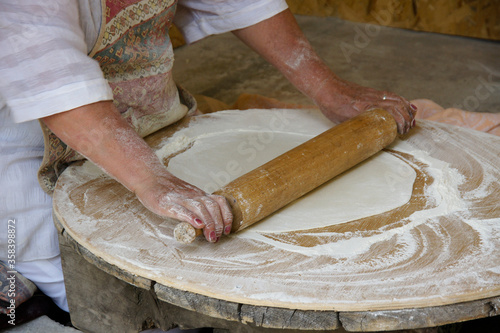 A woman rolls dough to make lavash (a traditional flatbread) which will then be baked in a tandoor oven, Garni, Armenia.