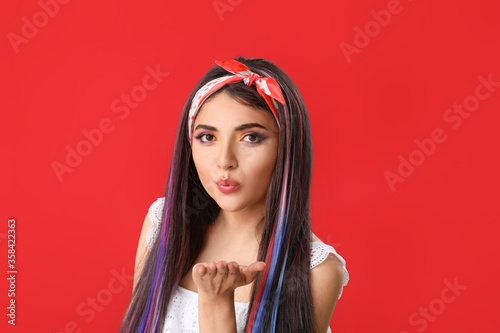 Beautiful young woman with unusual hair on color background
