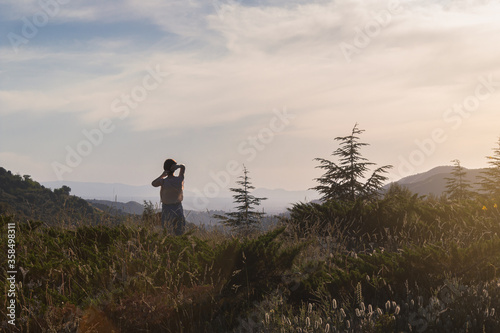 Nice woman looking at a mountain sunset while on vacation. Selective focus