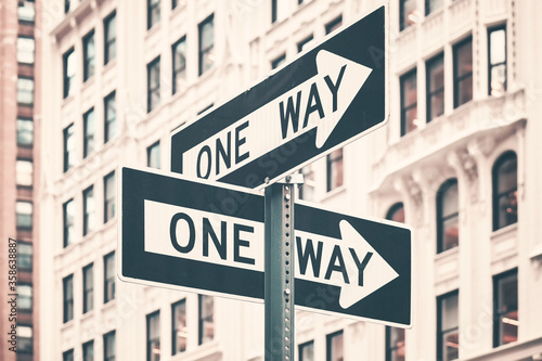 One way street arrow signs in New York City, color toning applied, USA.