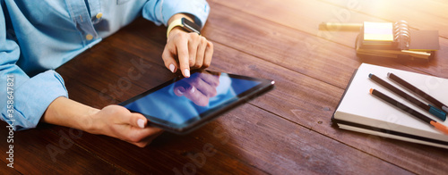 Woman pointing on digital tablet screen, chatting in social networks, meeting website, searching internet, sending sms, using text messenger or online banking. Close up photo
