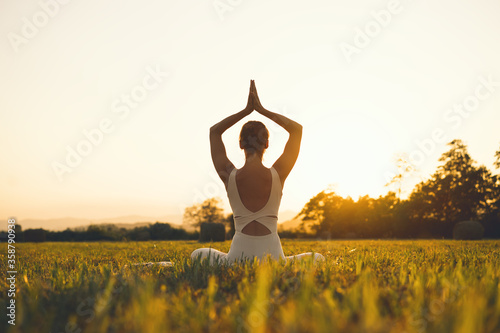 Young woman practicing yoga on nature.