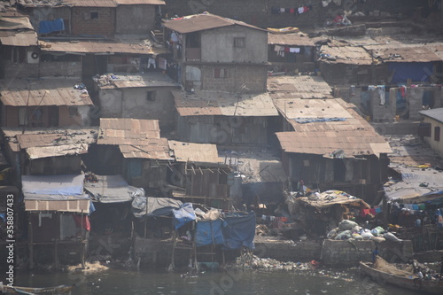 Shanty town in Freetown in Sierra Leone. Demolished and poor houses in the suburb of capital city. View from container ship berthed in port in container terminal port.