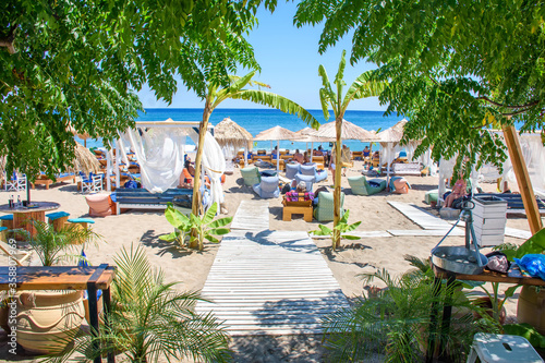 Umbrellas, sun beds and holiday-makers on Stegna beach (RHODES, GREECE)