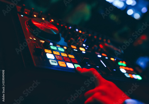 producer DJ mixer in a nightclub with glowing plays musical rave Dubstep Electronic Trance composition with modern midi controller device in nightclub Live.Musical production process for artists.