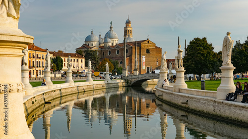 PADUA, ITALY - OCTOBER, 2017: Piazza Prato della Valle on Santa Giustina abbey. Prato della Valle elliptical square, surrounded by a small canal and bordered by two rings of statues.