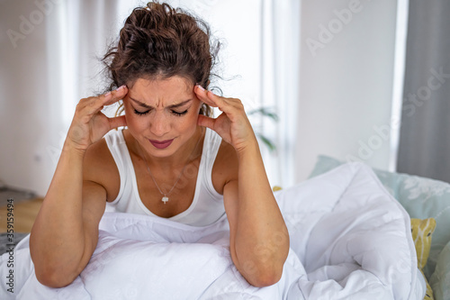 Young woman on bed, headache. Vertigo illness concept. Woman hands on his head felling headache dizzy sense of spinning dizziness,a problem with the inner ear, brain, or sensory nerve pathway.