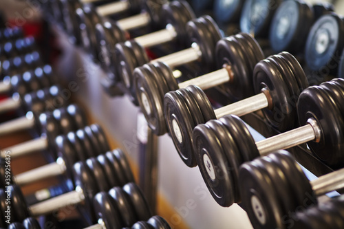 Rows of dumbbells in a fitness club on the background of gym.