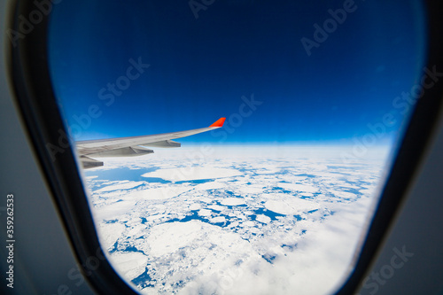 Amazing view of the glaciers and ocean from the porthole when flying over Greenland