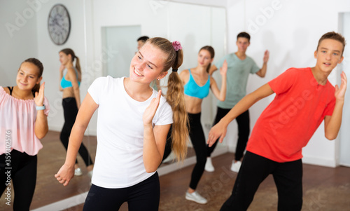 Teenage girl practicing dance with group