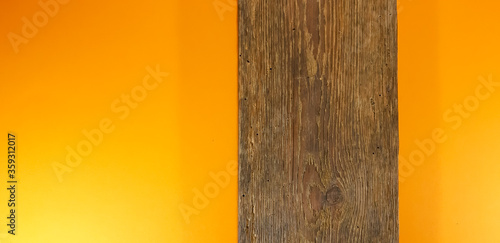 Stara brązowa deska na pomarańczowym tle.