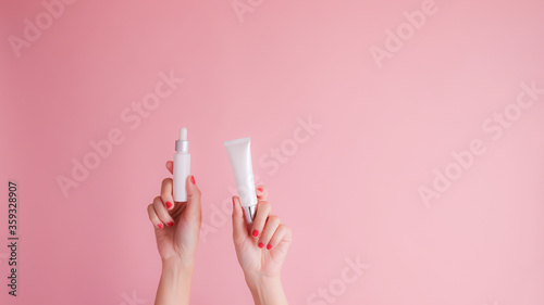 hand hold cosmetic skincare on pink background.beauty banner.